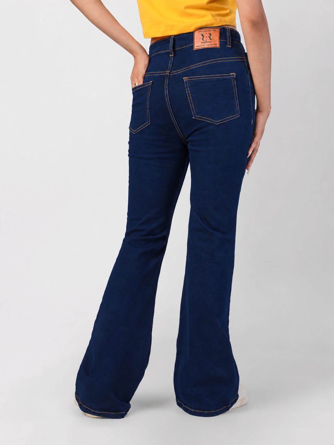 Dark blue bootcut jeans with back pockets and leather patch, well-fitted